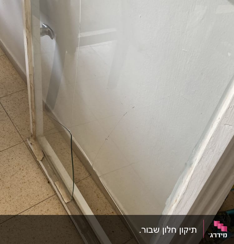 זכוכית שבורה במסגרת עץ לבנה על הרצפה